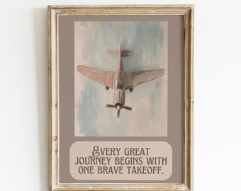 Op de afbeelding: Ingelijste kunstdruk met een vintage vliegtuig in vlucht, met een propeller aan de voorkant. Het kunstwerk heeft een gedempte kleurenpalet van bruin, grijs en blauw. De tekst onderaan luidt: "Every great journey begins with one brave takeoff."