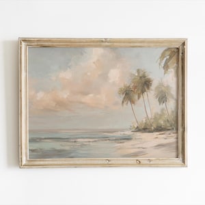May include: A framed landscape painting depicts a serene beach scene. The artwork features palm trees, a sandy shore, and gentle waves under a cloudy sky. The color palette includes soft blues, beige, and muted greens, creating a calming atmosphere.
