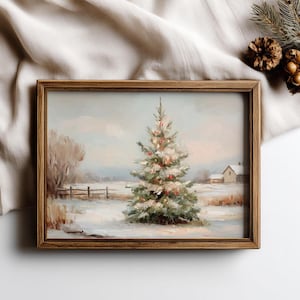 May include: A framed winter landscape painting featuring a snow-covered field and a decorated Christmas tree. The artwork has a rustic wooden frame and depicts a small house and a fence in the background. The color palette includes soft blues, greens, and whites.