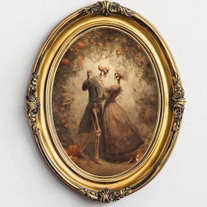 Op de afbeelding: Een ovaalvormig, goudomrand kunstwerk toont twee skeletten die in een romantische omhelzing dansen. De skeletten zijn gekleed in kleding uit die tijd, tegen een achtergrond van herfstbladeren en pompoenen. De lijst heeft sierlijke details.