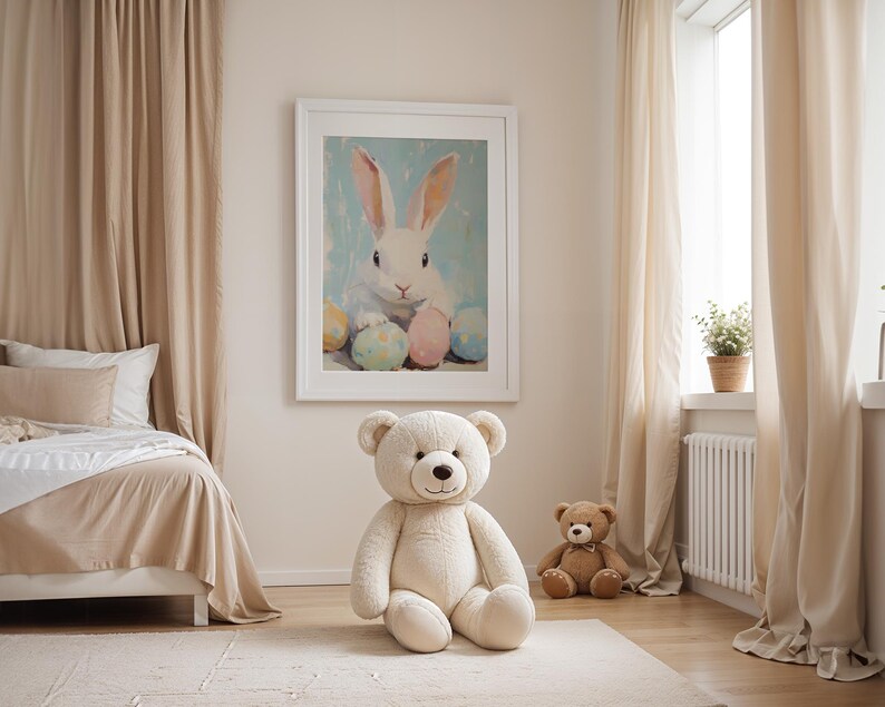 May include: A white teddy bear sitting on a beige rug in a room with a white bed, beige curtains, and a framed painting of a white rabbit with colorful Easter eggs.