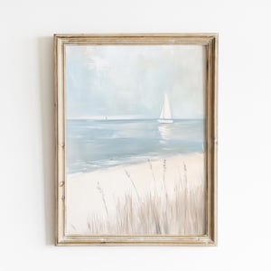 May include: A framed painting of a seascape with a sailboat in the distance and tall grasses in the foreground. The sky is a light blue and the water is a light blue-green. The sand is a light beige.