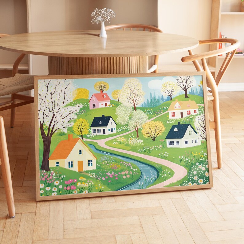May include: A framed illustration of a whimsical village scene with colorful houses, winding paths, and a flowing stream. The houses are painted in shades of pink, blue, yellow, and green, with white trim. The illustration is set against a backdrop of lush green trees and flowers.