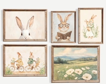 May include: A set of five framed art prints featuring watercolor illustrations. The prints depict rabbits in various scenes, including reading, riding bicycles, and a mother rabbit with her child. The color palette includes soft pastels and earth tones.