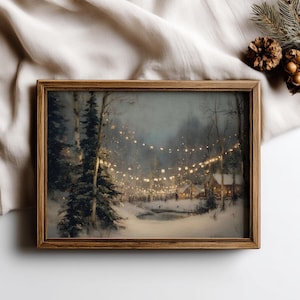 Pode incluir: Pintura emoldurada de uma paisagem de inverno com uma cena acolhedora e convidativa. A obra retrata um caminho florestal coberto de neve iluminado por fios de luzes, que leva a uma vila. A moldura é de madeira e a paleta de cores é suave com tons quentes.