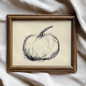 May include: A framed art print featuring a sketch of a pumpkin. The artwork is rendered in black lines on a cream-colored background. The frame is a warm brown color, adding a rustic touch to the piece. The overall theme is autumn and harvest.