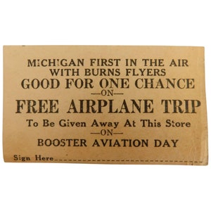 Puede incluir: Un billete vintage de color beige con texto negro. El texto dice "MICHIGAN FIRST IN THE AIR WITH BURNS FLYERS GOOD FOR ONE CHANCE ON FREE AIRPLANE TRIP." Tambi&eacute;n dice "To Be Given Away At This Store ON BOOSTER AVIATION DAY."
