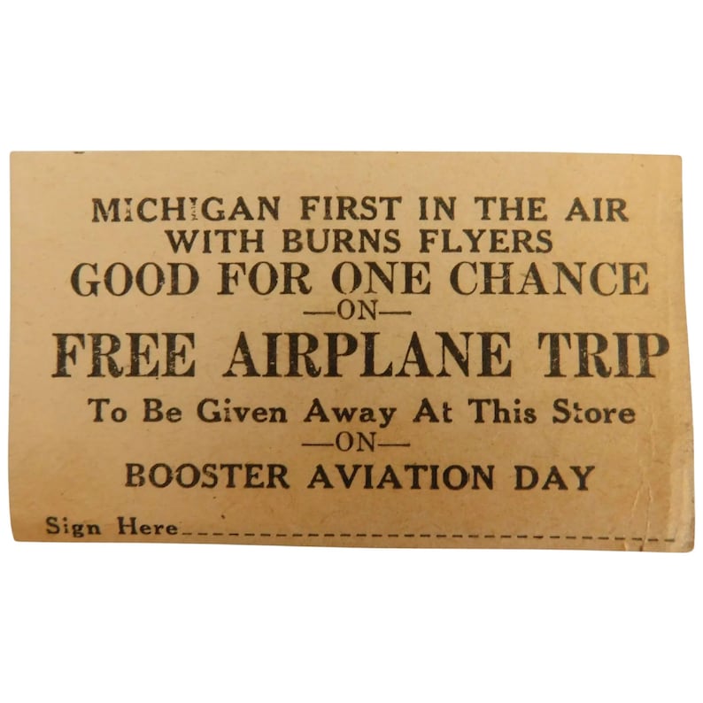 Puede incluir: Un billete vintage de color beige con texto negro. El texto dice "MICHIGAN FIRST IN THE AIR WITH BURNS FLYERS GOOD FOR ONE CHANCE ON FREE AIRPLANE TRIP." Tambi&eacute;n dice "To Be Given Away At This Store ON BOOSTER AVIATION DAY."