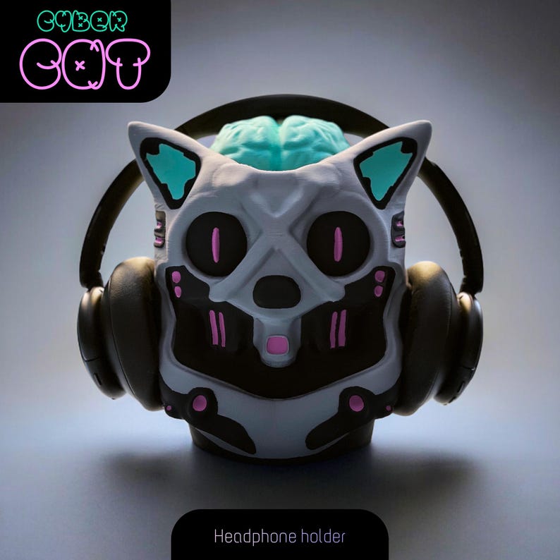 May include: A white and gray robot cat headphone holder with a blue brain and pink accents. The text "CYBER CAT" is in neon green and pink.