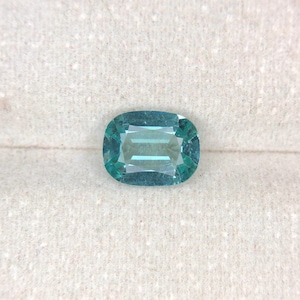 Könnte beinhalten: Ein hellblauer Edelstein mit rechteckiger Form, auf einem weißen Hintergrund.