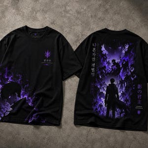 May include: A black short-sleeve t-shirt featuring a purple graphic of a character surrounded by shadows. The front displays a small emblem and text, while the back shows a large, detailed scene with Korean and Japanese characters.