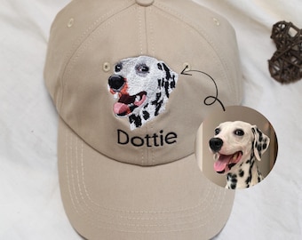 May include: Tan baseball cap with an embroidered Dalmatian dog portrait and the name "Dottie" in black. The cap features a curved brim and a button on top. A small circular image of the dog is shown next to the cap.