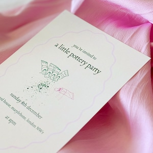 Puede incluir: Una tarjeta de invitación blanca con una ilustración verde de tubos de pintura y el texto "you're invited to a little pottery party" y "sunday 8th december" y "ard house, marylebone, london NWr" y "at 2pm".