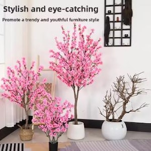 以下が含まれることがあります： 様々なサイズの人工桜の木と鉢植え。木にはピンクの花と茶色の幹があります。鉢は白と黒です。「Stylish and eye-catching」と「Promote a trendy and youthful furniture style」というテキストが上部にあります。