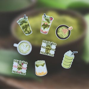 Könnte beinhalten: Eine Sammlung von Aufklebern zum Thema Matcha. Die Aufkleber zeigen verschiedene Matcha-Getränke, darunter Eiskaffee-Matcha, Matcha mit Schlagsahne und einen Matcha-Latte mit Latte Art. Einige Aufkleber tragen das Wort "Matcha".