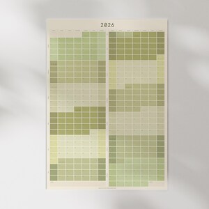 May include: A 2026 calendar with a Sunday start, displaying a grid of green and beige squares. The rectangular calendar has the year "2026" printed at the top. A circular sticker with the text "2026 Year Sunday Start Calendar" is on the right.