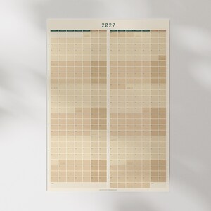 May include: A 2027 full-year wall calendar featuring a vertical layout with a Monday start. The design uses a neutral color palette of beige and tan squares to organize the months and days of the year in a grid format on a single sheet.