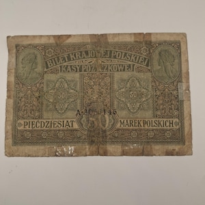 Puede incluir: Un billete polaco antiguo de 50 marcos con intrincados patrones decorativos en marrón y verde, dos retratos circulares, el texto Bilet Krajowej Polskiej Kasy Pożyczkowej, Piećdziesiat Marek Polskich y el número de serie A 3036146.