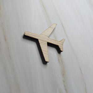 Può includere: Ritaglio di aereo in legno chiaro. L'aereo giocattolo ha un design semplice con ali, coda e fusoliera. L'aereo è un articolo per l'artigianato.