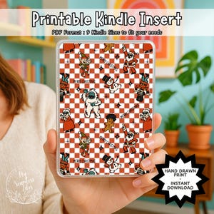 Könnte beinhalten: Ein Kindle-Einsatz mit einem festlichen Weihnachtsmuster mit Weihnachtsmann, Schneemännern, Elfen und anderen Weihnachtsfiguren auf einem rot-weiß karierten Hintergrund. Der Text "Printable Kindle Insert" ist sichtbar.