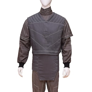 May include: A grey jumpsuit with a padded vest. The vest has a quilted design and a high collar. The jumpsuit has a straight leg and is made of a durable fabric.