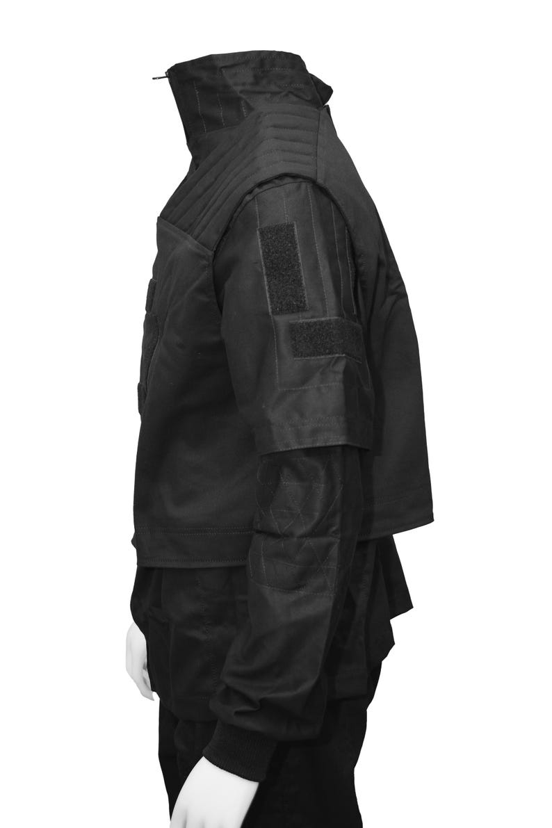 May include: Black tactical vest with multiple pockets and adjustable straps. The vest has a high collar and a zipper closure.