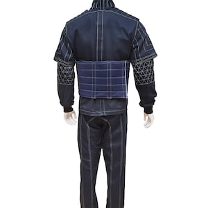 May include: A dark blue padded training suit with a white stitching detail. The suit includes a jacket and pants.