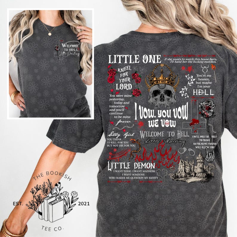 K&ouml;nnte beinhalten: Dunkelgraues T-Shirt mit floralem Muster und dem Text "Welcome to Hell, Little Darling". Die R&uuml;ckseite des Shirts zeigt gotische Texte und Grafiken, darunter ein Sch&auml;del mit Krone, Rosen und die Worte "Little One" und "Little Demon".
