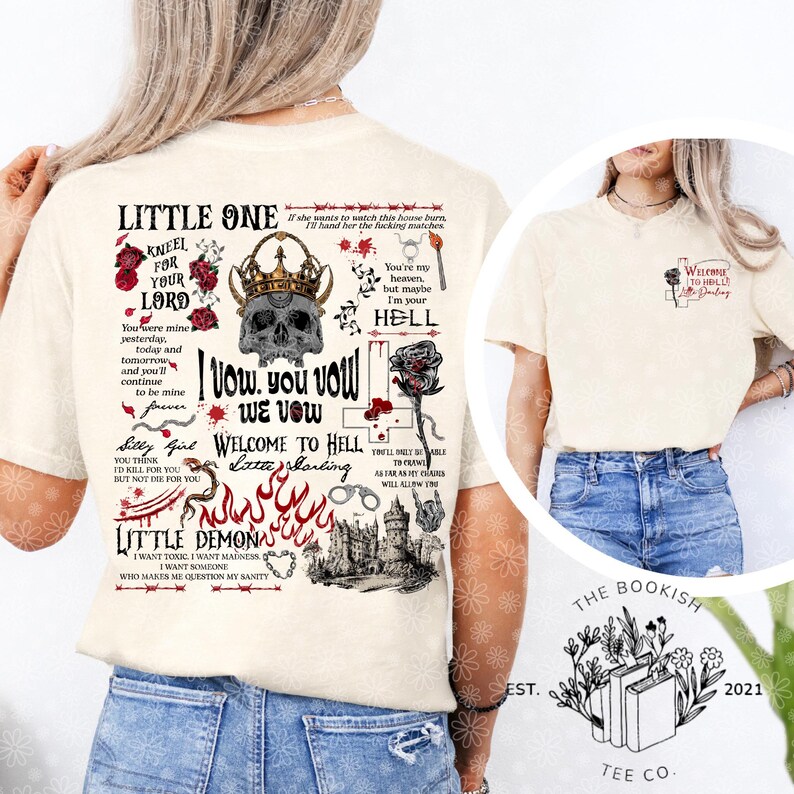 K&ouml;nnte beinhalten: Cremefarbenes T-Shirt mit einem grafischen Design mit einem Sch&auml;del mit Krone, Rosen und Text. Der Text enth&auml;lt S&auml;tze wie "Little One", "Welcome to Hell" und "I vow". Das Logo von The Bookish Tee Co. ist sichtbar.