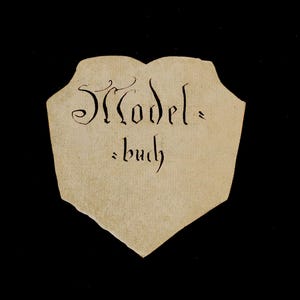 May include: A tan paper tag with the text "Model-buch" written in black ink.