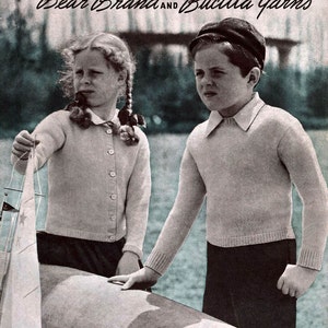 Può includere: Una copertina di rivista vintage con due bambini che indossano maglioni di lana. La copertina è intitolata "Children's Book Bear Brand AND Bucilla Yarns" e ha il testo "Vol. 320 25¢ (IN U.S.A.)".