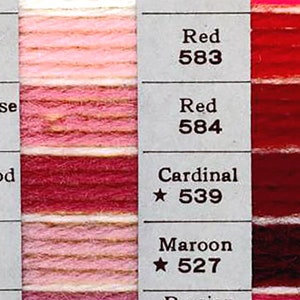Puede incluir: Una carta de colores con muestras de hilo en tonos de rosa, rojo y granate. La carta incluye los nombres y los números de cada color, como "Cameo 514", "Rosa Salvaje 526" y "Cardinal 539".