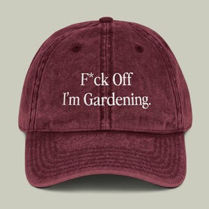 May include: A maroon vintage-style baseball cap with the text "F*ck Off I'm Gardening." embroidered in white.