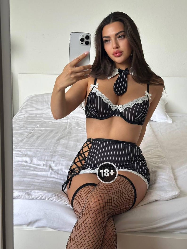 May include: Black and white striped lingerie set with a matching tie and white collar. The set includes a bra, skirt, and thigh-high stockings. The skirt features a lace-up design on the side and a white lace trim.
