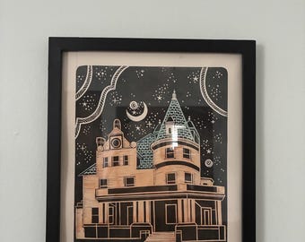 May include: Framed art print of a Victorian-style house under a starry night sky. The house is tan with black detailing, a blue-green turret roof, and a porch. The background is black with white stars and a crescent moon.