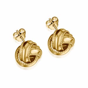 May include: A pair of gold knot-shaped earrings with a twisted rope design. The earrings have a post and butterfly back closure.