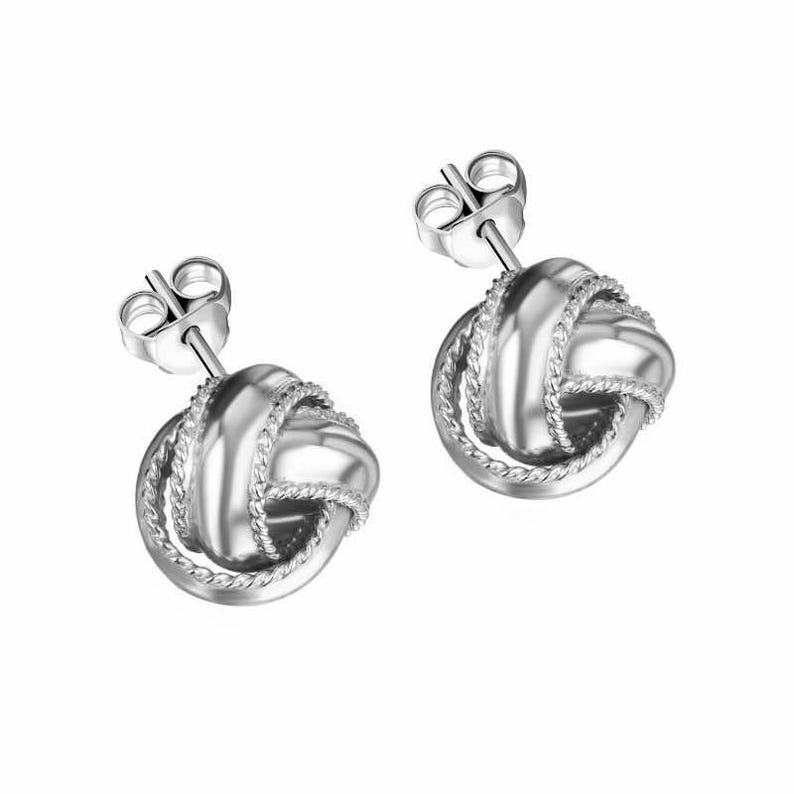 May include: A pair of silver knot-shaped earrings with a twisted rope design.
