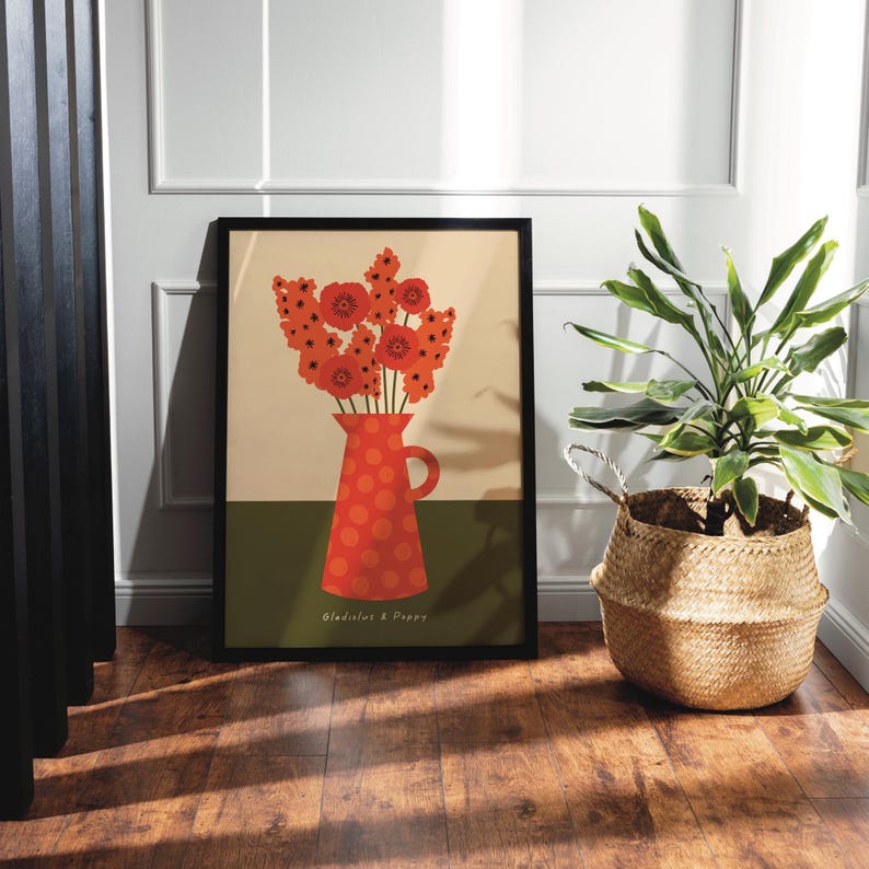 Framed wall art print in red, orange and olive green featuring gladioluses and the poppies in a polka dot vase. There is text below the vase in a hand-written font that lists the flowers.
