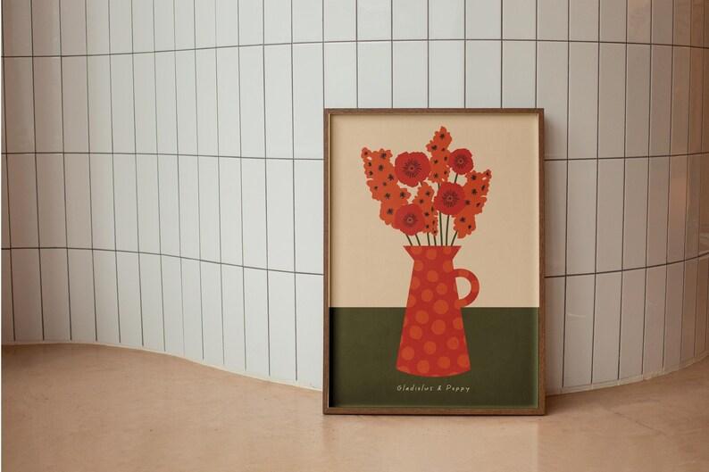 Framed wall art print in red, orange and olive green featuring gladioluses and the poppies in a polka dot vase. There is text below the vase in a hand-written font that lists the flowers.