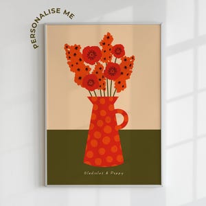 Framed wall art print in red, orange and olive green featuring gladioluses and the poppies in a polka dot vase. There is text below the vase in a hand-written font that lists the flowers.