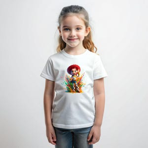 May include: White t-shirt featuring a colorful graphic of a cartoon character with a red hat. The character is surrounded by vibrant paint splashes. The shirt is worn by a young person with long, light brown hair and blue jeans.