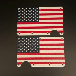 May include: Two rectangular metal plates featuring a printed American flag design with red, white, and blue colors. Each plate has a series of small circular holes along the edges and a larger semi-circular cutout on one side for functional access.