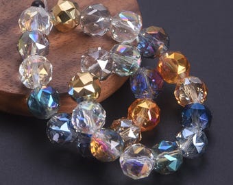 May include: Strand of faceted crystal beads in various colors, including clear, gold, blue, and orange. The beads are strung together on a thin, clear cord, and are displayed on a wooden surface.