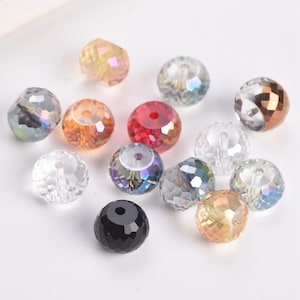 May include: A collection of faceted beads in various colors, including clear, red, orange, and iridescent hues. The beads have a round shape with multiple facets, creating a sparkling effect. These beads are suitable for jewelry making and crafting projects.