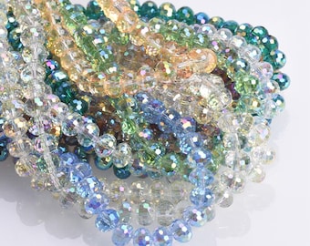 May include: Strands of iridescent crystal beads in various colors, including blue, green, yellow, and clear. The beads are faceted, reflecting light and creating a sparkling effect. These beads are suitable for jewelry making and craft projects.