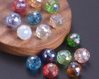 May include: A collection of faceted, round beads in various colors, including red, blue, green, and clear. The beads have a sparkling, iridescent quality and are arranged on a wooden surface.