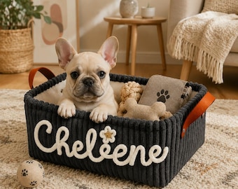 May include: A rectangular dark gray corduroy storage basket with tan leather handles. The front features the white embroidered name Cheleene with a small flower accent. A cream-colored French Bulldog puppy sits inside with a bone toy and a paw print tag.