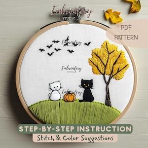 May include: An embroidery hoop containing white fabric with a stitched scene of a white cat, a black cat, an orange pumpkin, a green grassy hill, a yellow tree, and black bats. The text Embroidery Studio X and PDF PATTERN are visible.