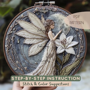 Pode incluir: Uma peça de arte bordada detalhada em um bastidor, apresentando uma fada com asas texturizadas e um vestido esvoaçante. O design inclui um lírio branco, uma lua cheia e o texto "PDF PATTERN" e "STEP-BY-STEP INSTRUCTION Stitch & Color Suggestions".