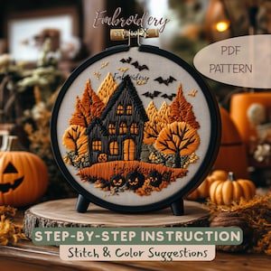 May include: A round black embroidery hoop containing a fabric panel with a stitched scene of a dark house, orange and yellow trees, and three jack-o'-lanterns. The design includes black bats, the text Embroidery Studio X, and PDF PATTERN.